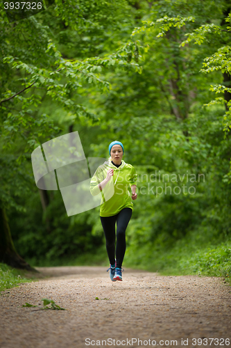 Image of Sporty young female runner in the forest. 