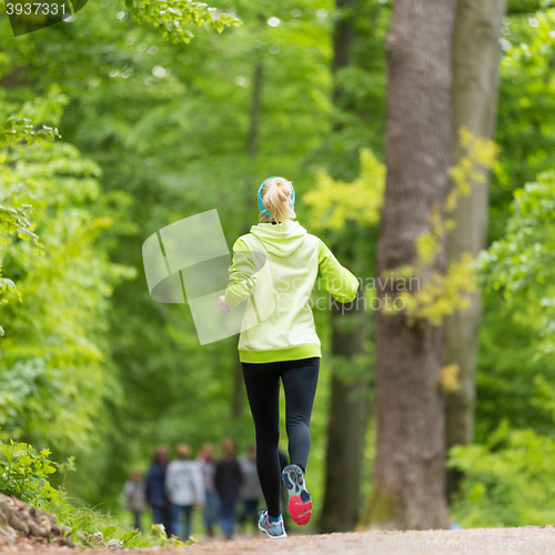 Image of Sporty young female runner in the forest. 