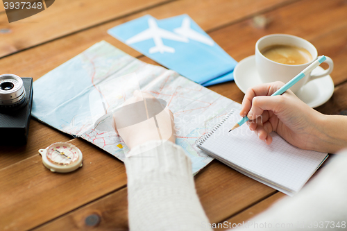 Image of close up of traveler hands with notepad and pencil