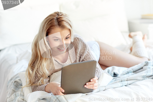 Image of happy young woman with tablet pc in bed at home