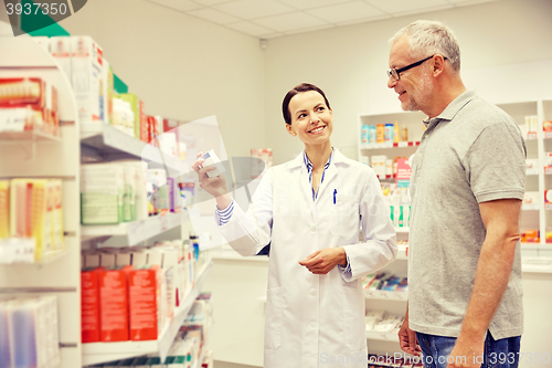 Image of pharmacist showing drug to senior man at pharmacy