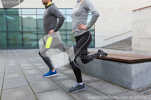 Image of close up of couple doing lunge exercise on street