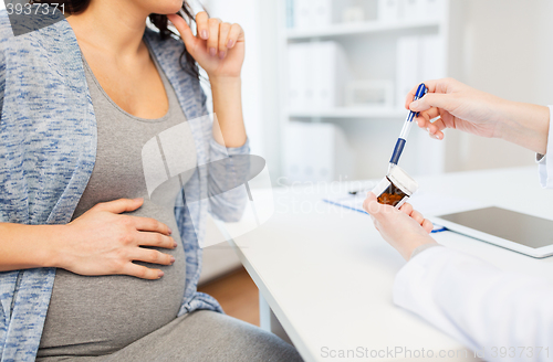 Image of close up of doctor showing pills to pregnant woman