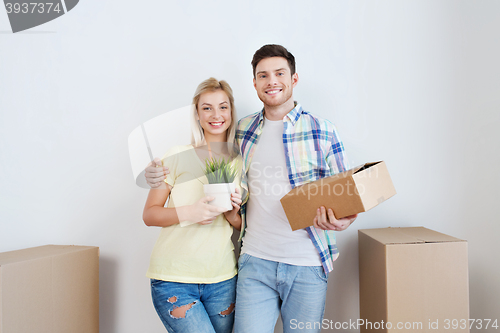 Image of smiling couple with big boxes moving to new home