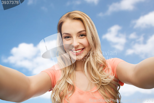 Image of happy smiling young woman taking selfie