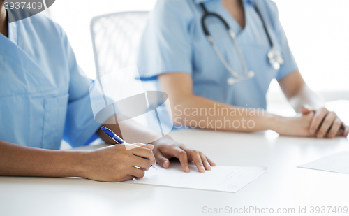 Image of close up of doctor taking notes at hospital