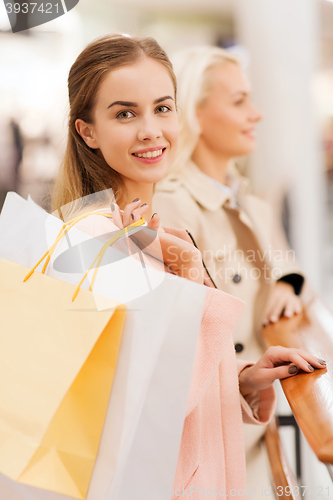 Image of happy young women with shopping bags in mall