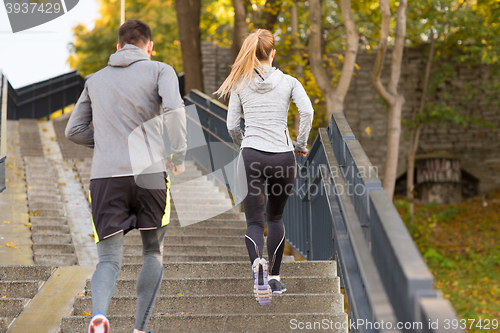 Image of couple running upstairs in city park