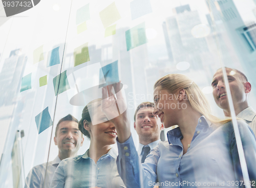 Image of smiling business people with marker and stickers