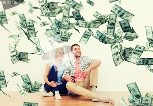 Image of happy couple at home over dollar money falling