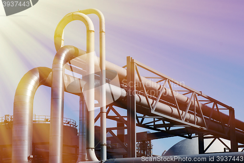 Image of industrial pipelines on pipe-bridge against blue sky