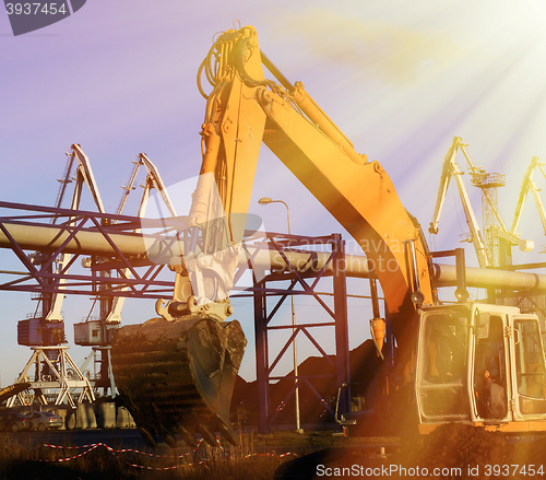 Image of Hydraulic excavator at work. Shovel bucket against blue sky