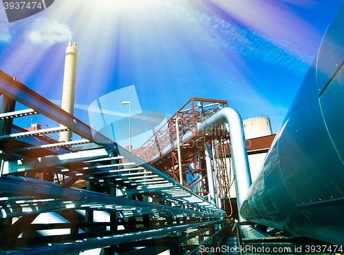 Image of Industrial zone, Steel pipelines and smokestack on blue sky    