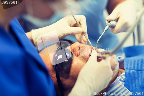 Image of close up of dentists treating teeth at clinic