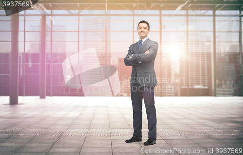 Image of smiling businessman over empty hall and city