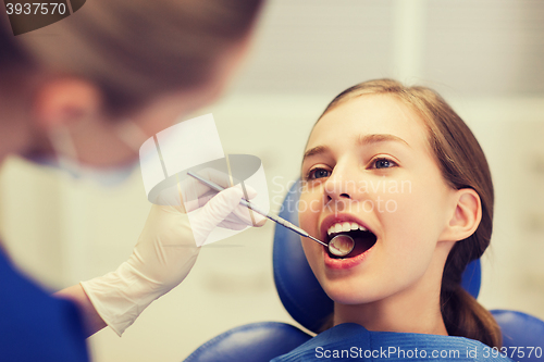 Image of female dentist checking patient girl teeth