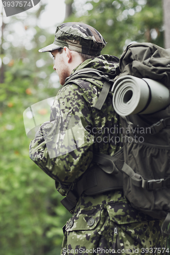 Image of young soldier with backpack in forest