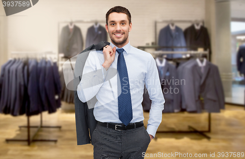 Image of happy young businessman over clothing store