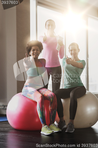 Image of group of smiling women with exercise balls in gym