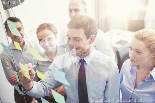 Image of smiling business people with marker and stickers