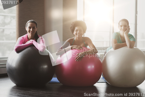 Image of group of smiling women with exercise balls in gym