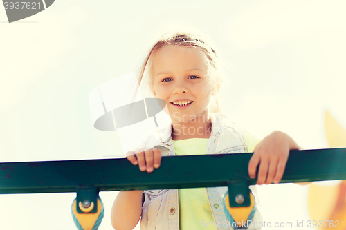 Image of happy little girl climbing on children playground