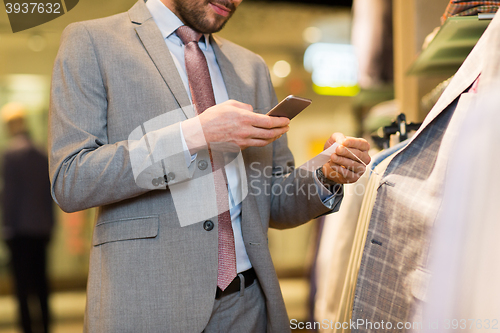 Image of close up of man with smartphone at clothing store