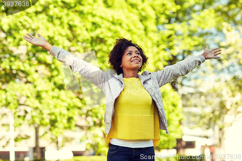 Image of happy african american young woman in summer park