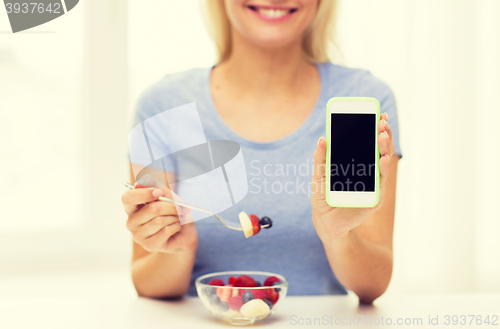 Image of close up of woman with smartphone eating salad