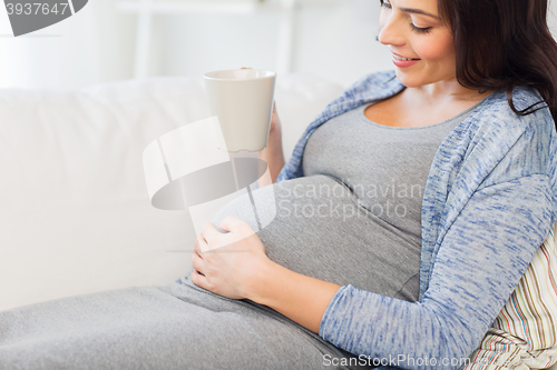 Image of close up of pregnant woman drinking tea at home