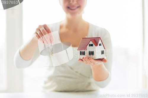 Image of close up of woman holding house model and keys