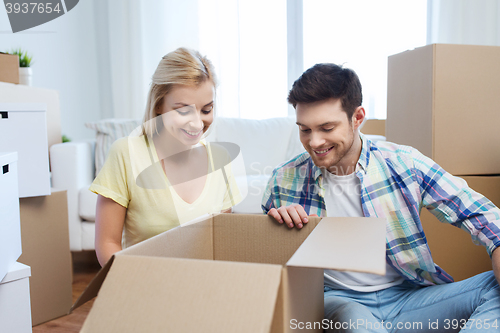 Image of smiling couple with big boxes moving to new home