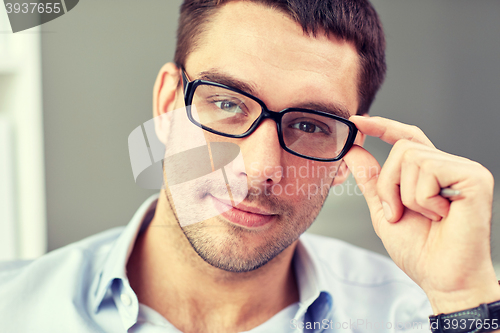 Image of portrait of businessman in eyeglasses at office