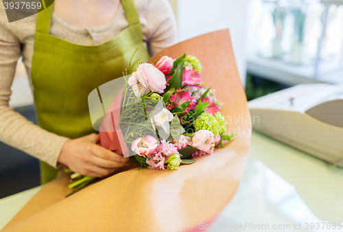 Image of close up of woman packing bunch at flower shop