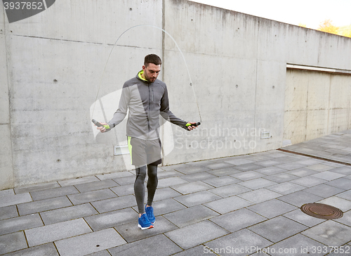 Image of man exercising with jump-rope outdoors