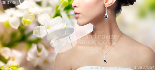 Image of close up of woman with earring and pendant