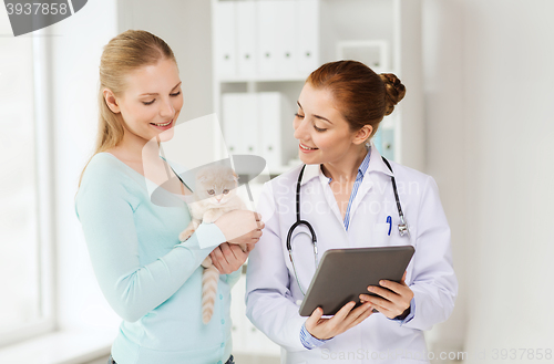 Image of happy woman with cat and doctor at vet clinic