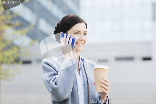 Image of smiling woman with coffee calling on smartphone
