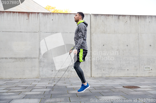 Image of man exercising with jump-rope outdoors