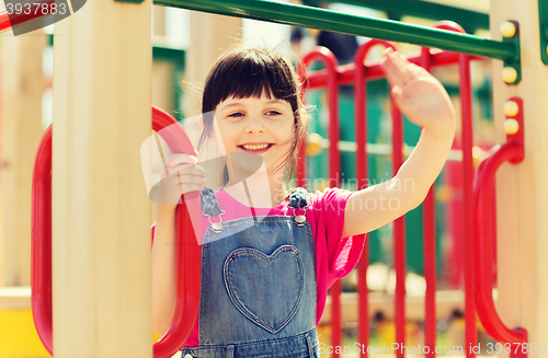 Image of happy little girl climbing on children playground