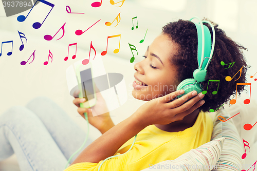 Image of happy african woman with smartphone and headphones