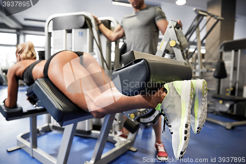 Image of man and woman flexing muscles on gym machine