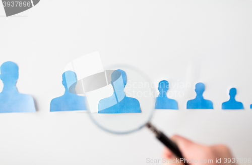 Image of close up of paper human shapes on white board