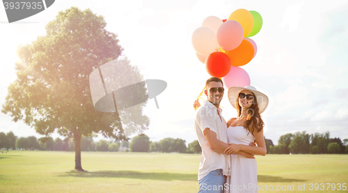 Image of smiling couple with air balloons outdoors