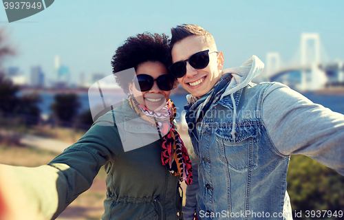 Image of happy teenage couple taking selfie in tokyo