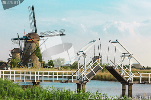 Image of beautiful traditional dutch windmills near the water channels with drawbridge