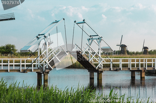 Image of beautiful traditional dutch windmills near the water channels with drawbridge