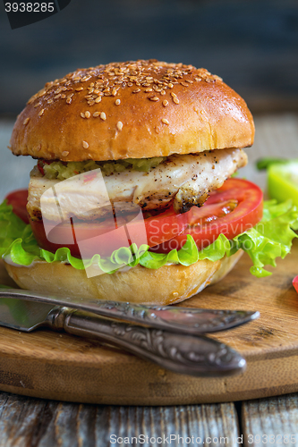 Image of Burger with chicken, hot sauce and salad.