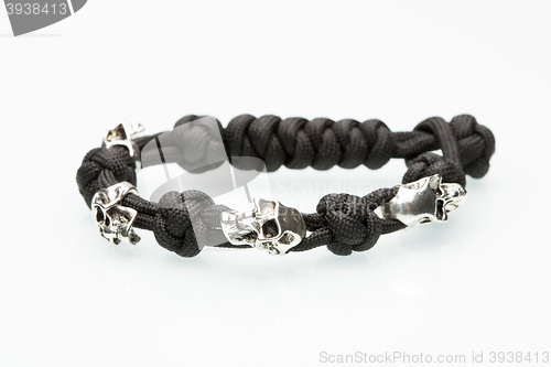 Image of Black braided bracelet with skulls on white background