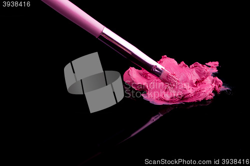 Image of lipstick with a brush make-up on black 